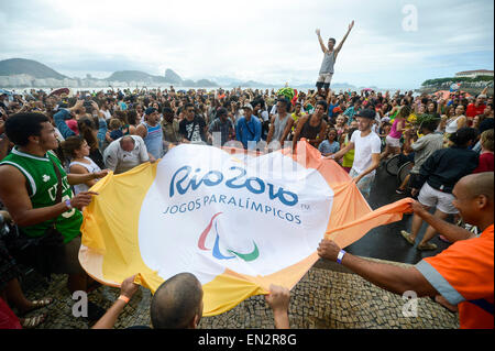 Rio De Janeiro, Brasile. 26 apr, 2015. Onda di persone una bandiera con il logo di Rio 2016 Giochi Paralimpici per contrassegnare i 500 giorni il conto alla rovescia per Rio 2016 Giochi Paralimpici presso la spiaggia di Copacabana a Rio de Janeiro, Brasile, 26 aprile 2015. Credito: Rio 2016 Comitato organizzatore/Xinhua/Alamy Live News Foto Stock