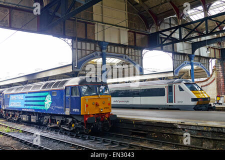 Direct Rail Services Class 47 locomotive diesel in piedi alla stazione di Norwich , Abellio maggiore Anglia elettrico accanto alla piattaforma. Foto Stock