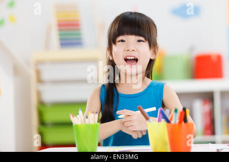 La bambina della pittura nella scuola materna Foto Stock