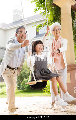 Mia nonna e mio nonno con un piccolo nipote swing Foto Stock