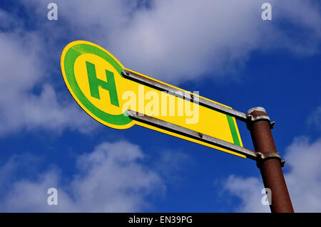 Fermata bus segno, cielo blu, il bianco delle nuvole Foto Stock