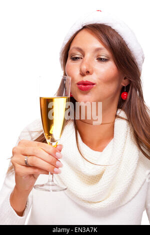 Giocoso donna che indossa una festa di Santa Red Hat e tenendo un calice di champagne per celebrare il Natale soffia un bacio attraverso il p Foto Stock