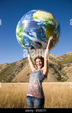 Stati Uniti d'America, Utah, sud Forcella, Ritratto di ragazza adolescente (16-17) azienda globo gonfiabile palla in Prato Foto Stock