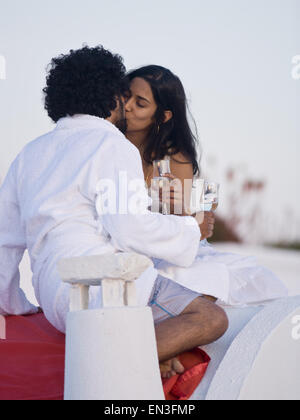 Giovane baciare e snuggling all aperto con champagne flauti Foto Stock