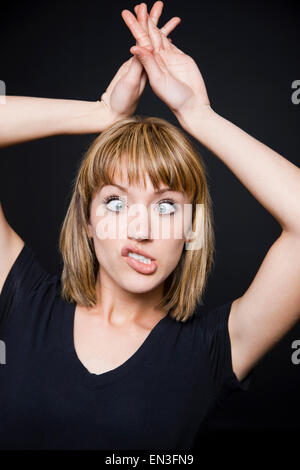 Giovane donna tirando funny faces Foto Stock