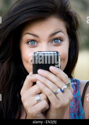 Stati Uniti d'America, Utah, sud Forcella, Ritratto di felice ragazza adolescente (16-17) tenendo il telefono cellulare Foto Stock