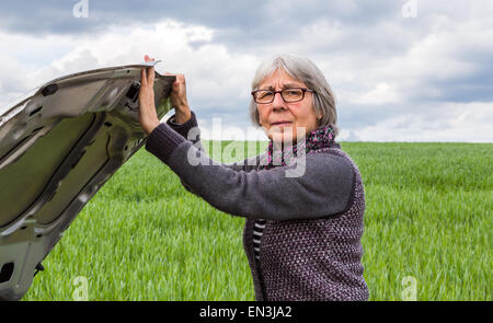 Auto ha breakdown donna Senior si apre il cofano. Foto Stock