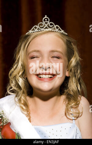 Concorso di bellezza vincitore sorridente e tenendo le rose Foto Stock