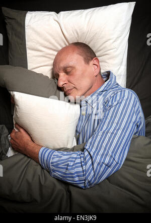Uomo in pigiama o jammies dormire nel letto Foto Stock
