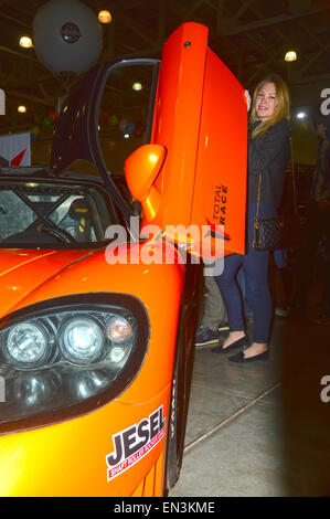 Mosca Tuning Show 2015 giovane bella ragazza in posa vicino al visitatore della mostra con una Saleen arancione Foto Stock