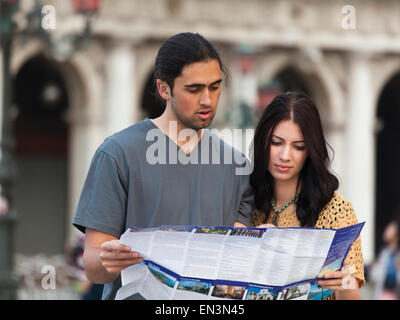 L'Italia, Venezia, coppia giovane guardando la mappa su Piazza San Marco Foto Stock