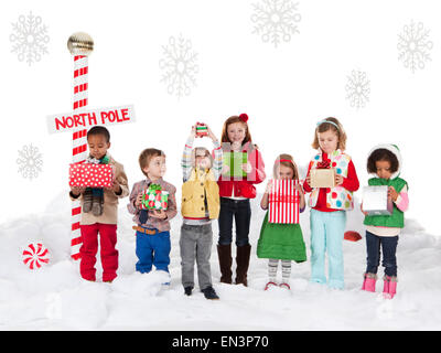 Gruppo di bambini (18-23mesi, 2-3, 4-5, 6-7) in piedi accanto al Polo Nord segno Foto Stock