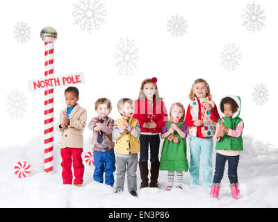 Gruppo di bambini (18-23mesi, 2-3, 4-5, 6-7) in piedi accanto al Polo Nord segno Foto Stock