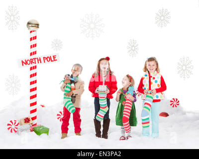 Gruppo di bambini (18-23mesi, 4-5,6-7) in piedi accanto al Polo Nord segno Foto Stock