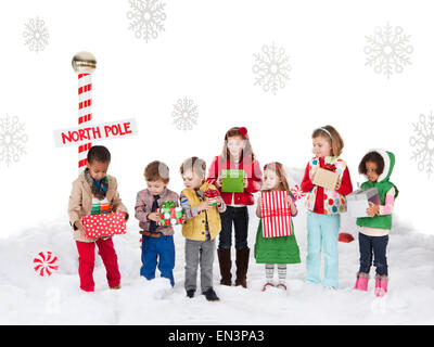 Gruppo di bambini (18-23mesi, 2-3, 4-5, 6-7) in piedi accanto al Polo Nord segno Foto Stock