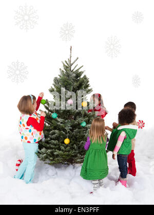 Gruppo di bambini (18-23mesi, 4-5,6-7) in piedi intorno all albero di natale Foto Stock