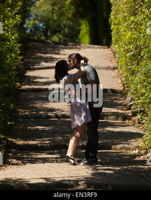 L'Italia, Firenze, coppia romantica baciare in vicolo orlate da alberi Foto Stock