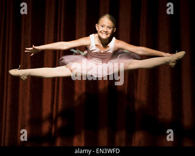 Ballerina ragazza sul palco che saltava e sorridente Foto Stock