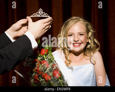 Concorso di bellezza vincitore sorridente e tenendo le rose Foto Stock