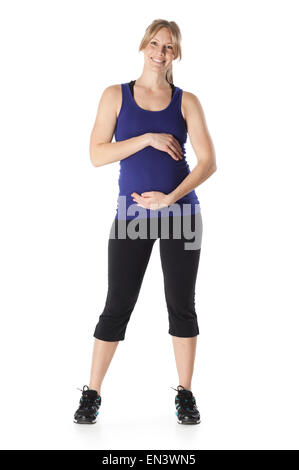 Ritratto di giovane donna incinta in capi di abbigliamento sportivi, studio shot Foto Stock