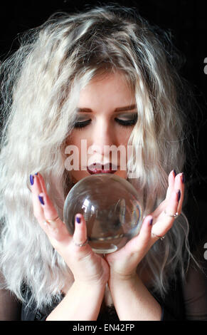 Bella giovane donna in possesso di una sfera di cristallo Foto Stock