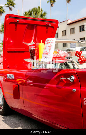 Vassoio di vetro al drive-in diner.. Il coke, patatine fritte e un hamburger...tutti sul lato del Vostro 1960 red T-Bird Foto Stock