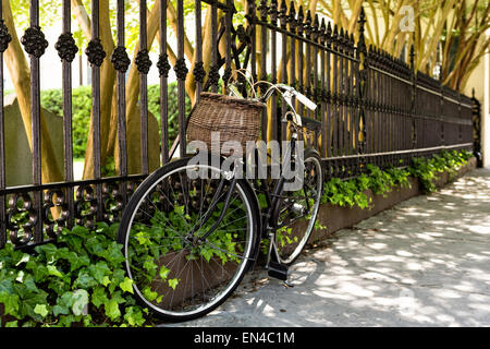 Una bicicletta vintage incatenato al recinto dei Francesi Ugonotti Chiesa lungo Church Street nel quartiere storico di Charleston, Sc. Foto Stock