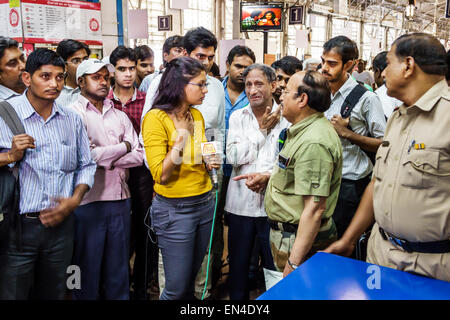 Mumbai India,stazione ferroviaria Churchgate,linea occidentale,treno,donna donna donne,giornalista TV,reporter,media,intervista,interviste,microfono,intervistato Foto Stock