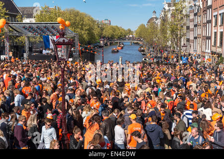 Amsterdam Koningsdag sul Torensluis ponte sul canale Singel con una festa folla su un soleggiato re della giornata. Foto Stock