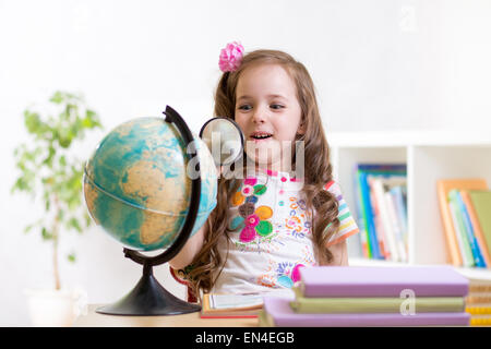 Bambino di lettura con lente di ingrandimento di guardare il mondo Foto Stock