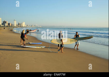 Gruppo di surfisti per adulti con tavole da surf preparando a fare surf alla mitica Golden Mile beach in mattina presto, Durban, Sud Africa Foto Stock