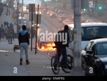 Baltimore, Stati Uniti d'America. 27 apr, 2015. Un automobile brucia in Baltimore, Maryland, Stati Uniti, 27 aprile 2015. Il Governatore del Maryland Larry Hogan lunedì sera ha dichiarato lo stato di emergenza e attivato la guardia nazionale per affrontare l'escalation di violenza e disordini nella città di Baltimora dopo il funerale di un 25-anno-vecchio uomo nero che è morto dopo essere stato ferito in custodia della polizia. Credito: Yin Bogu/Xinhua/Alamy Live News Foto Stock