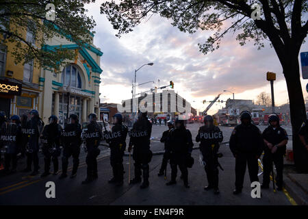 Baltimore, Stati Uniti d'America. 27 apr, 2015. Guardia di poliziotti nei pressi di una farmacia CVS store che è stato dato alle fiamme in Baltimore, Maryland, Stati Uniti, 27 aprile 2015. Il Governatore del Maryland Larry Hogan lunedì sera ha dichiarato lo stato di emergenza e attivato la guardia nazionale per affrontare l'escalation di violenza e disordini nella città di Baltimora dopo il funerale di un 25-anno-vecchio uomo nero che è morto dopo essere stato ferito in custodia della polizia. Credito: Yin Bogu/Xinhua/Alamy Live News Foto Stock