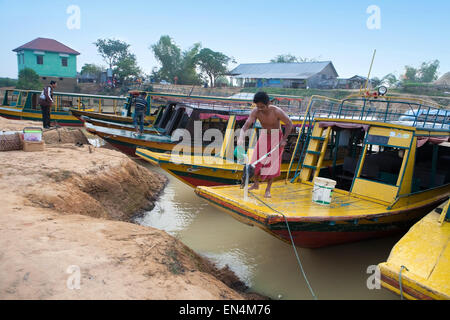 Cambogia - dic 29 Un uomo lavando il suo spazzolone per la pulizia la sua nave passeggeri al lago Tonle Sap, Cambogia 29 Dicembre 2013 Foto Stock