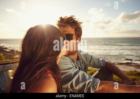 Affettuosa coppia giovane baciare sulla spiaggia. Amare giovane coppia con mare in background. Coppia romantica in vacanza. Foto Stock