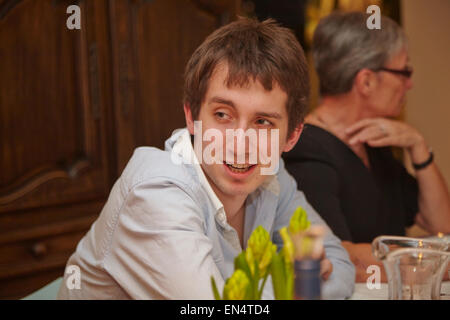 Un giovane a una festa di Capodanno con cena in famiglia; a Bruxelles, Belgio. Foto Stock