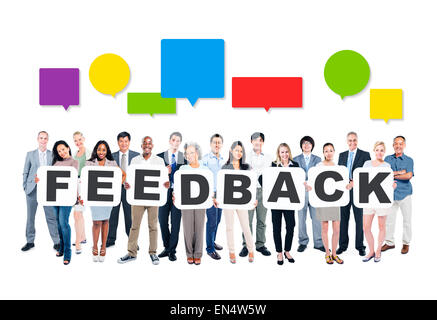 Multi-Ethnic Gruppo di diverse persone che trattengono le lettere che formano il feedback e colorato discorso vuoto bolle al di sopra di Foto Stock