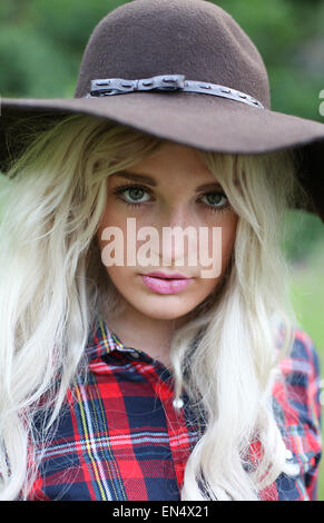 Bella sano giovane donna all'aperto indossando grande floppy hat e verifica shirt Foto Stock