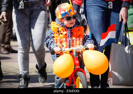 Voorschoten, Paesi Bassi. 27th, aprile 2015. Un giovane ragazzo è visto su una bici decorate in arancione, la nazionale di colore usato per la celebrazione del compleanno del re. Credito: Jaap Arriens/Alamy Live News Foto Stock