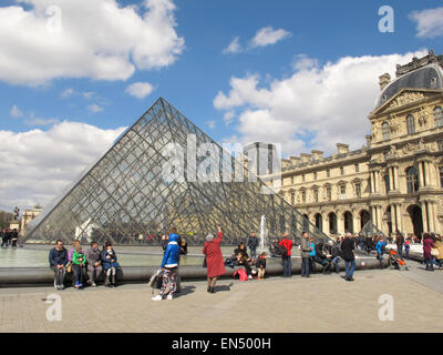 Parigi, Francia. 5 apr, 2015. I turisti ed i visitatori a piedi passato la piramide di vetro, la principale area dell'entrata al museo del Louvre a Parigi, Francia, 5 aprile 2015. Foto: Jens Kalaene/dpa - nessun filo SERVICE -/dpa/Alamy Live News Foto Stock