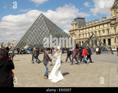 Parigi, Francia. 5 apr, 2015. I turisti ed i visitatori a piedi passato la piramide di vetro, la principale area dell'entrata al museo del Louvre a Parigi, Francia, 5 aprile 2015. Foto: Jens Kalaene/dpa - nessun filo SERVICE -/dpa/Alamy Live News Foto Stock