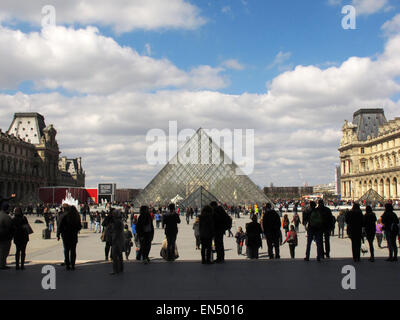 Parigi, Francia. 5 apr, 2015. I turisti ed i visitatori a piedi passato la piramide di vetro, la principale area dell'entrata al museo del Louvre a Parigi, Francia, 5 aprile 2015. Foto: Jens Kalaene/dpa - nessun filo SERVICE -/dpa/Alamy Live News Foto Stock