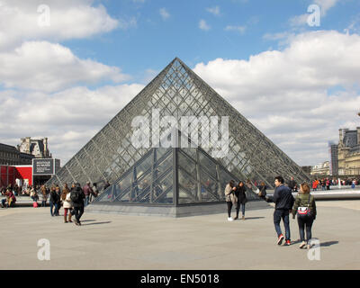 Parigi, Francia. 5 apr, 2015. I turisti ed i visitatori a piedi passato la piramide di vetro, la principale area dell'entrata al museo del Louvre a Parigi, Francia, 5 aprile 2015. Foto: Jens Kalaene/dpa - nessun filo SERVICE -/dpa/Alamy Live News Foto Stock