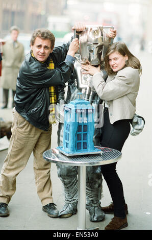 Dr Who, Sylvester McCoy con il suo assistente Ace alias Sophie Aldred visto qui con un cyberman il taglio di una torta con la forma del tardis durante un photocall BBC per promuovere la nuova serie di medico che. 15 Novembre 1988 Foto Stock