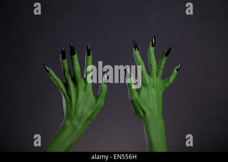 Green monster mani con forte black chiodi, tema Halloween, studio shot su sfondo nero Foto Stock