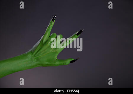 Green monster mano mostra heavy metal gesto, studio shot su sfondo nero Foto Stock