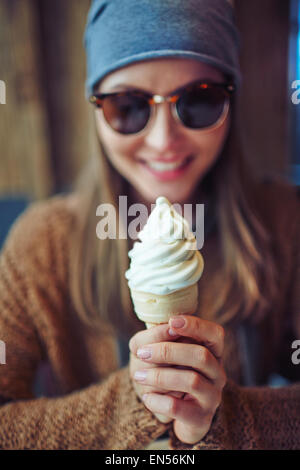 Giovane donna tenendo cono gelato Foto Stock