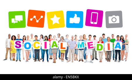 Multi-etnico gruppo di persone azienda cartoni formando i social media e i relativi simboli sopra. Foto Stock