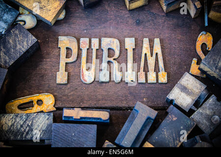 La parola PURIM scritto in metallo arrugginito lettere circondato da vintage in legno e metallo tipo di stampa in rilievo. Foto Stock