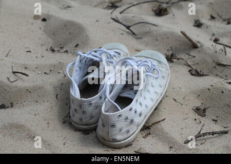 La luce bianca fast sneakers resto sulla soleggiata spiaggia sabbiosa Foto Stock